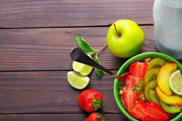 Oatmeals in green plate decorated with slice of strawberry, kiwi
