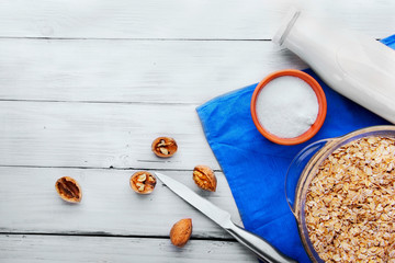 Oatmeals in glass casserole, bottle of milk, plate with shugar,