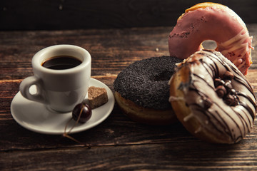fresh donut with coffee on wooden table with napkin, spoon and c