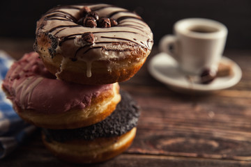 fresh donut with coffee on wooden table with napkin, spoon and c