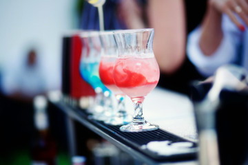 Bartender preparing a cocktail with blue and red syrup