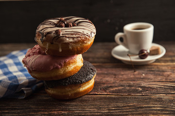 fresh donut with coffee on wooden table with napkin, spoon and c