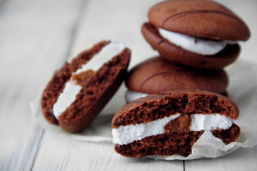 Broken cookies and stack of sponge cookies with cream on paper. closeup.Selective focus
