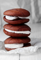 Stack of sponge cookies with cream on paper.closeup