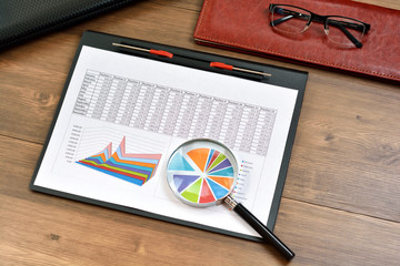 Financial paper charts and graphs on the table.