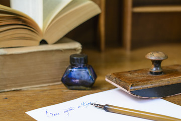 Text “Once upon a time” handwritten in ink surrounded with a fountain pen, an ink pot, a...