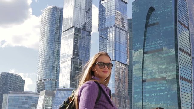 Beautiful woman tourist standing on the background of a large skyscraper