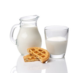 Jug and glass with milk and cookies with jam isolated on white background