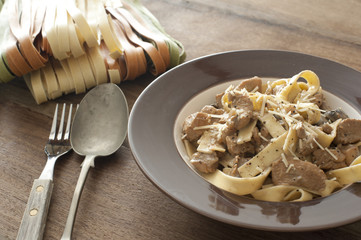 Chicken tagliatelle pasta and bowl on table