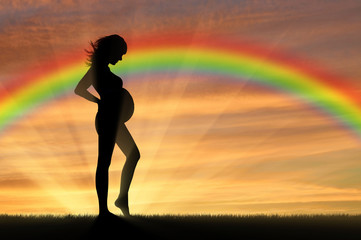 Pregnant woman on the background of the rainbow