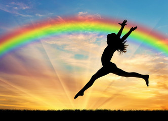 Happy woman jumping near rainbow