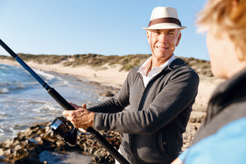 Senior man fishing with his grandson