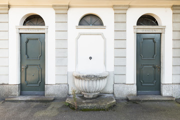Eine nicht mehr gebrauchte, öffentliche Toilette im alten Stil für Männer und Frauen mit grünen...