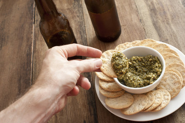 Man dipping a cracker in a savory dip
