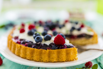 Delicious sponge cake with jelly and with fresh forest fruit with whipped cream and mascarpone.