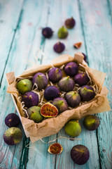 Ripe figs in a wooden box on a wooden table.