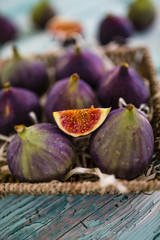 Ripe figs in a basket on a wooden table.