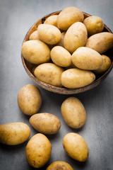 New potato on the bowl, gray background.