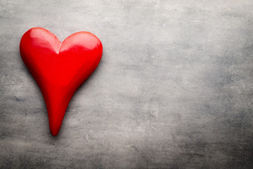 Red heart on the gray metal background.