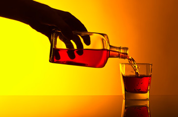 bottle and glass of whiskey on a glass table