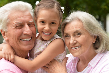 Grandparents with granddaughter in park