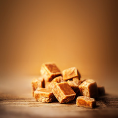 Caramel candies over dark  background.Golden Butterscotch toffee