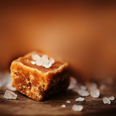 Salted caramel pieces and sea salt close up, top view. Buttersco