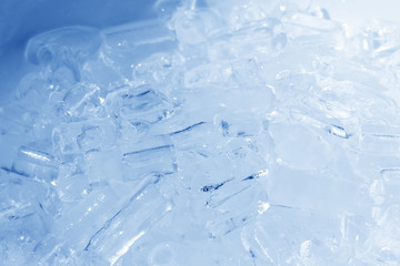 Pile blue ice in a white ceramic bowl, close up cold water in a circle plate