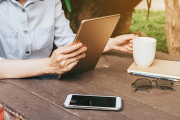 Asian woman using tablet in garden at coffee shop with vintage t