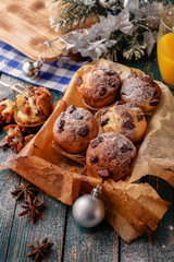 Chocolate muffins with powdered sugar on the wooden table, rusti