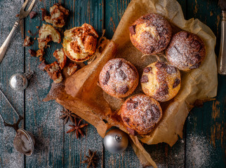 Chocolate muffins with powdered sugar on the wooden table, rusti