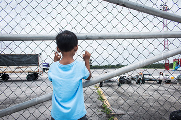 Behind of little boy sad standing alone