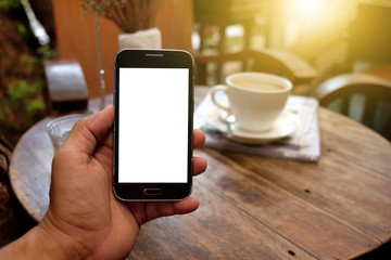 Smart phone in hand with coffee blurred background.