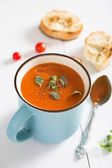 Tomato soup with herbs in a mug