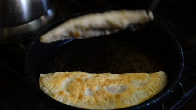 Housewife roasts chebureks in pan - Georgian national dish