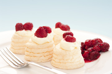 Meringues and cream with raspberries