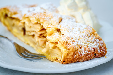 Apfelstrudel mit Puderzucker und Sahne
