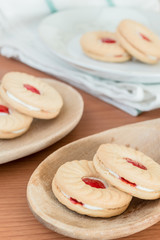 Fototapeta na wymiar Sweet cookies with cream and jam on wood background