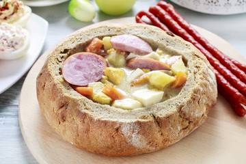Obraz na płótnie Canvas The sour rye soup inside loaf of bread