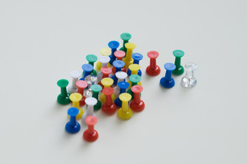 Closeup of colorful pushpin on cream background.