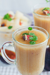 A delicious fresh melon and fig smoothie in a glass with a slice
