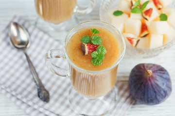 A delicious fresh melon and fig smoothie in a glass with a slice
