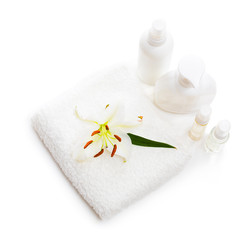 Flower white Lily lying on a towel and bottles