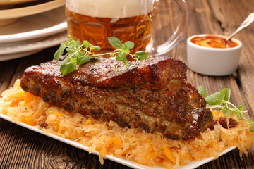 Fried pork ribs with herbs on wooden background