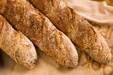Three fresh Alpine Baguettes with seeds and cereal flakes.