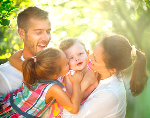 Happy joyful young family with children having fun outdoors in orchard garden