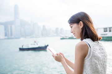 Fototapeta na wymiar Woman using cellphone in Hong Kong