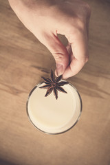 woman who lay in a glass of milk Dried star anise as a spice to flavor and taste