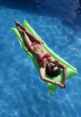 beautiful woman in bikini lying relax on float airbed at vacacti