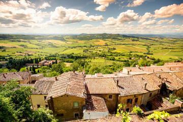 Beautiful landscape view on the meadow with old buildings in Montepulciano town in Italy - obrazy, fototapety, plakaty